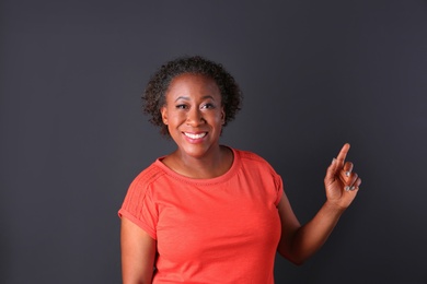 Portrait of happy African-American woman on black background