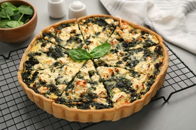 Delicious homemade spinach quiche on light gray table