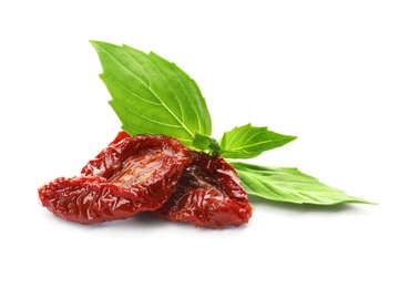 Tasty sun dried tomatoes with green leaves on white background