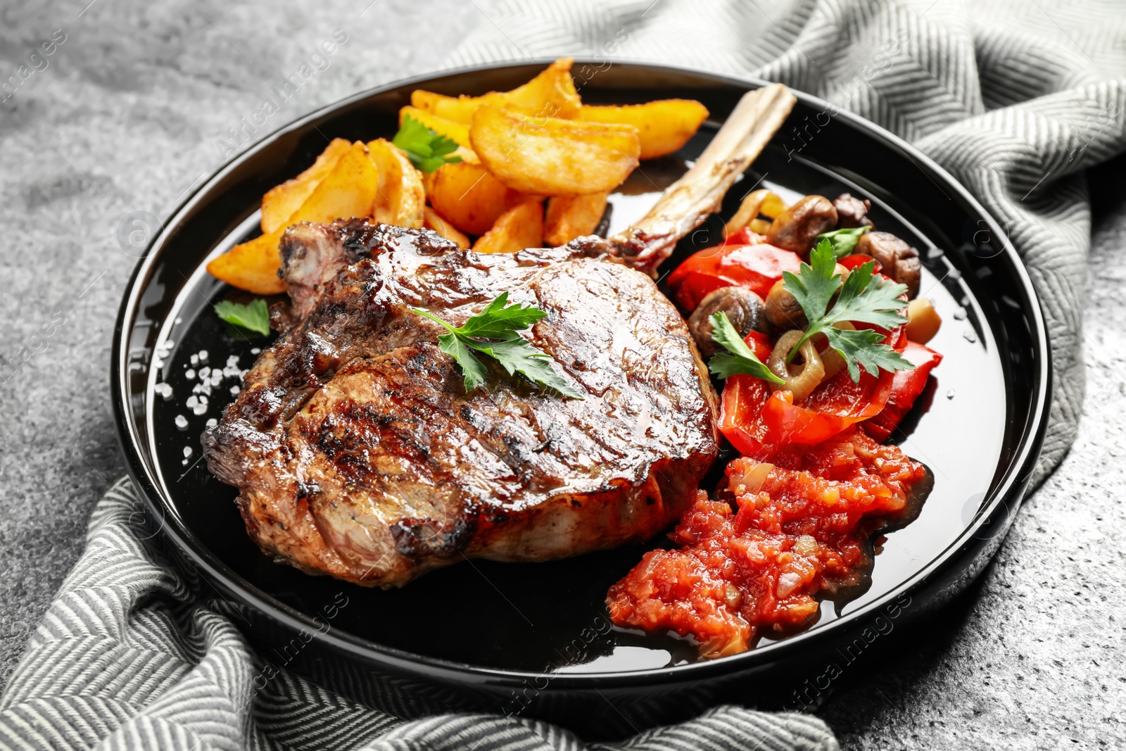 Photo of Delicious grilled ribeye served on grey table