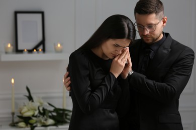 Photo of Sad couple mourning in room. Funeral ceremony
