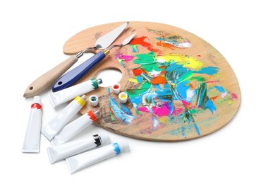 Photo of Palette with acrylic paints and spatulas on white background. Artist equipment