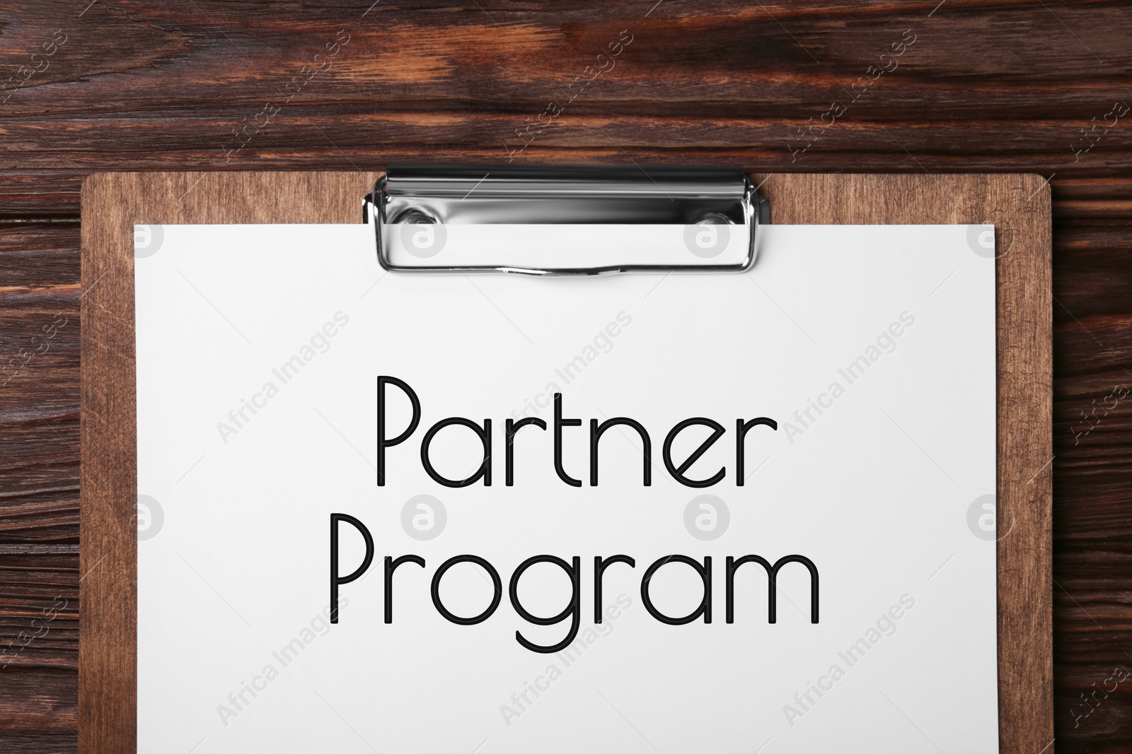 Image of Partner program. Clipboard with paper on wooden table, top view