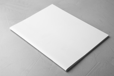 Photo of Blank book on light grey stone background. Mock up for design