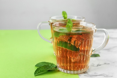 Cups of refreshing iced tea on table