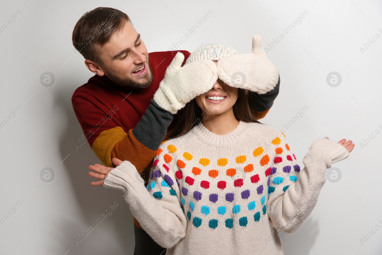 Photo of Young couple in warm sweaters on white background