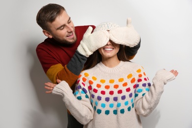 Young couple in warm sweaters on white background