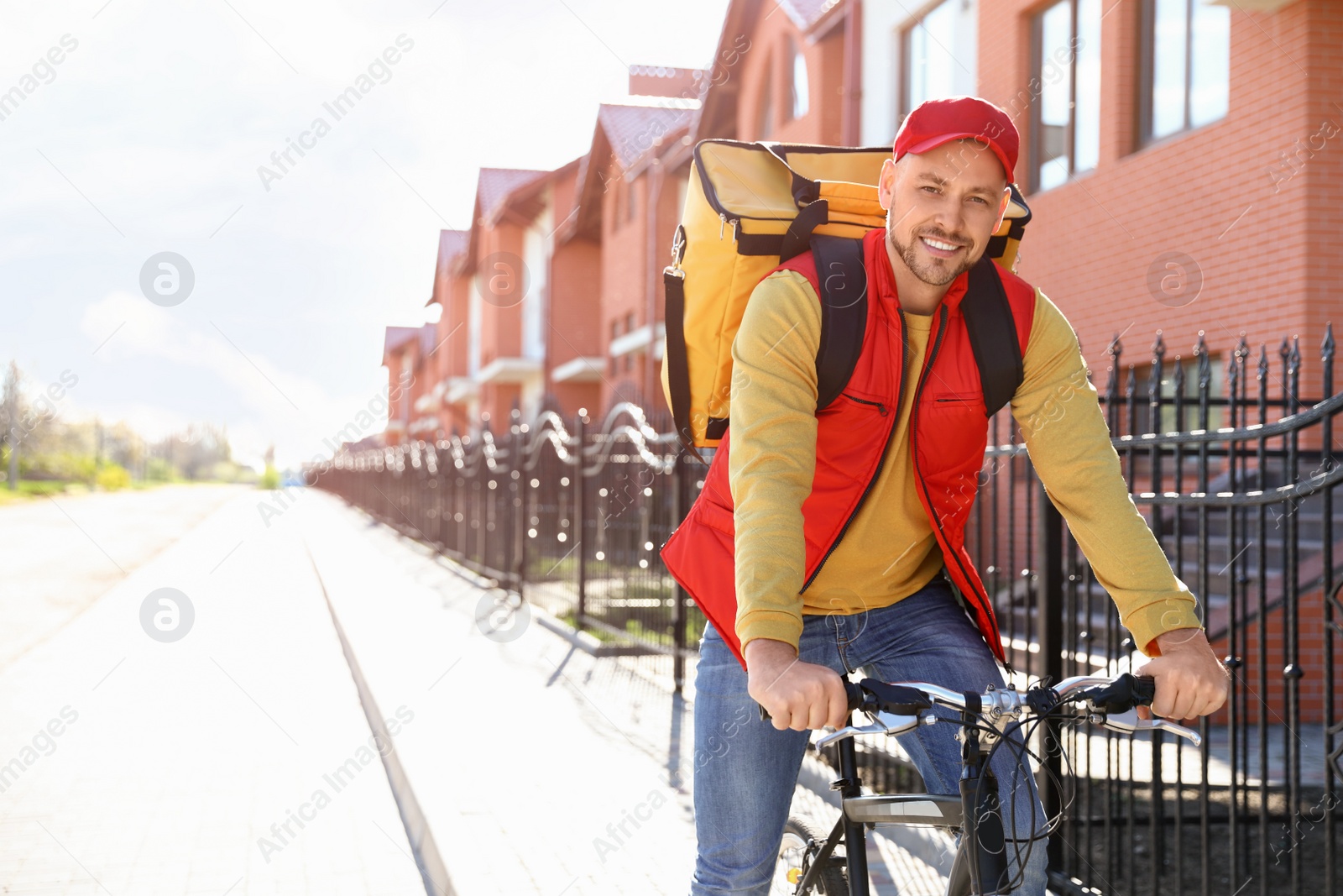 Photo of Male courier on bicycle delivering food in city