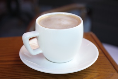 Aromatic coffee on wooden table outdoors, closeup