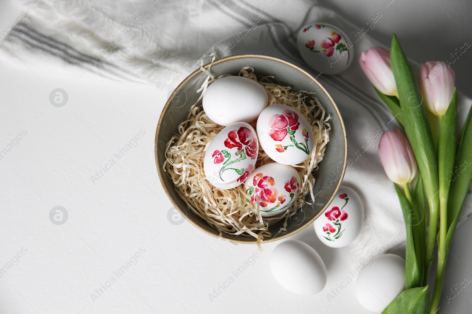 Photo of Flat lay composition with painted Easter eggs on white table, space for text