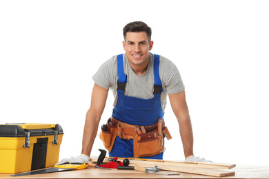 Handsome carpenter working with timber at wooden table on white background