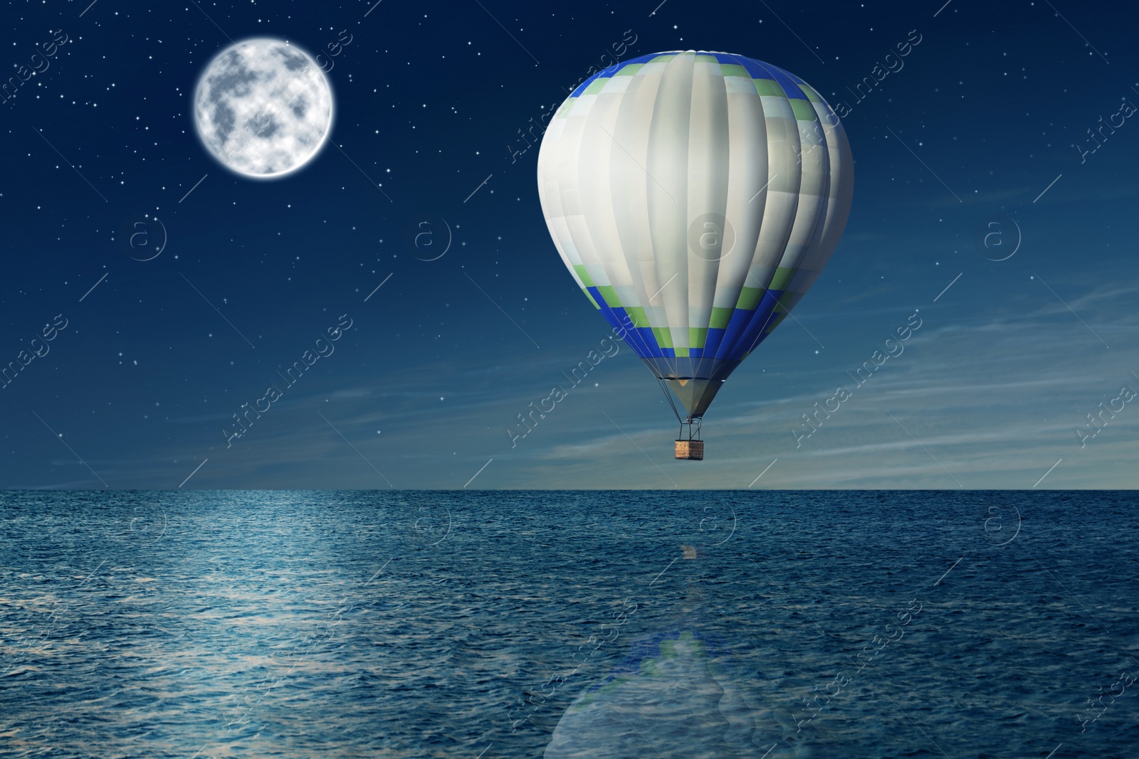 Image of Dream world. Hot air balloon in night sky with full moon over sea