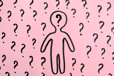 Photo of Picture of human figure and question marks on pink background, top view
