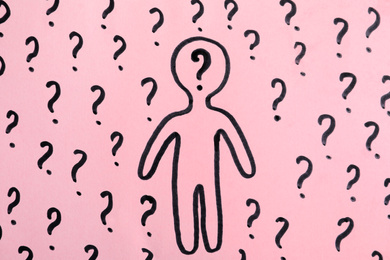 Picture of human figure and question marks on pink background, top view