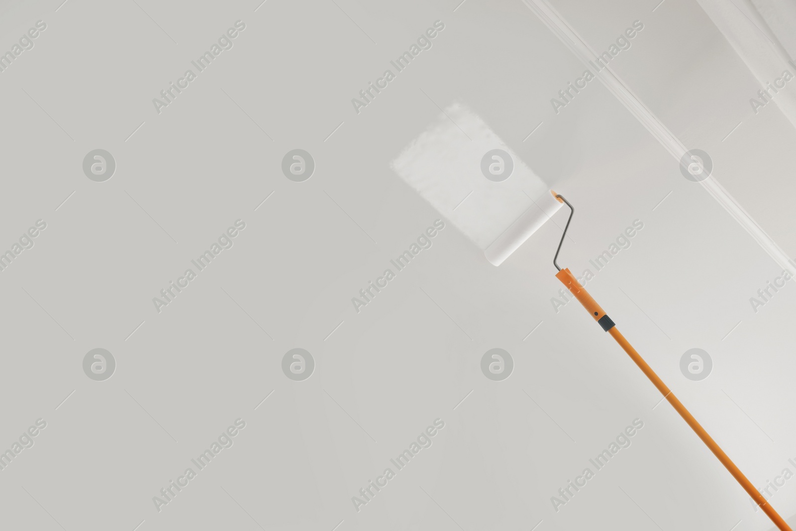 Photo of Painting ceiling with white dye indoors, low angle view. Space for text