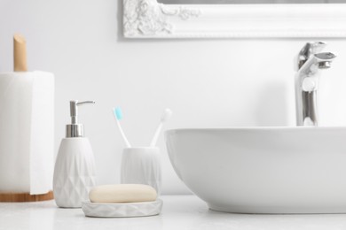 Photo of Different bath accessories and personal care products near sink on bathroom vanity