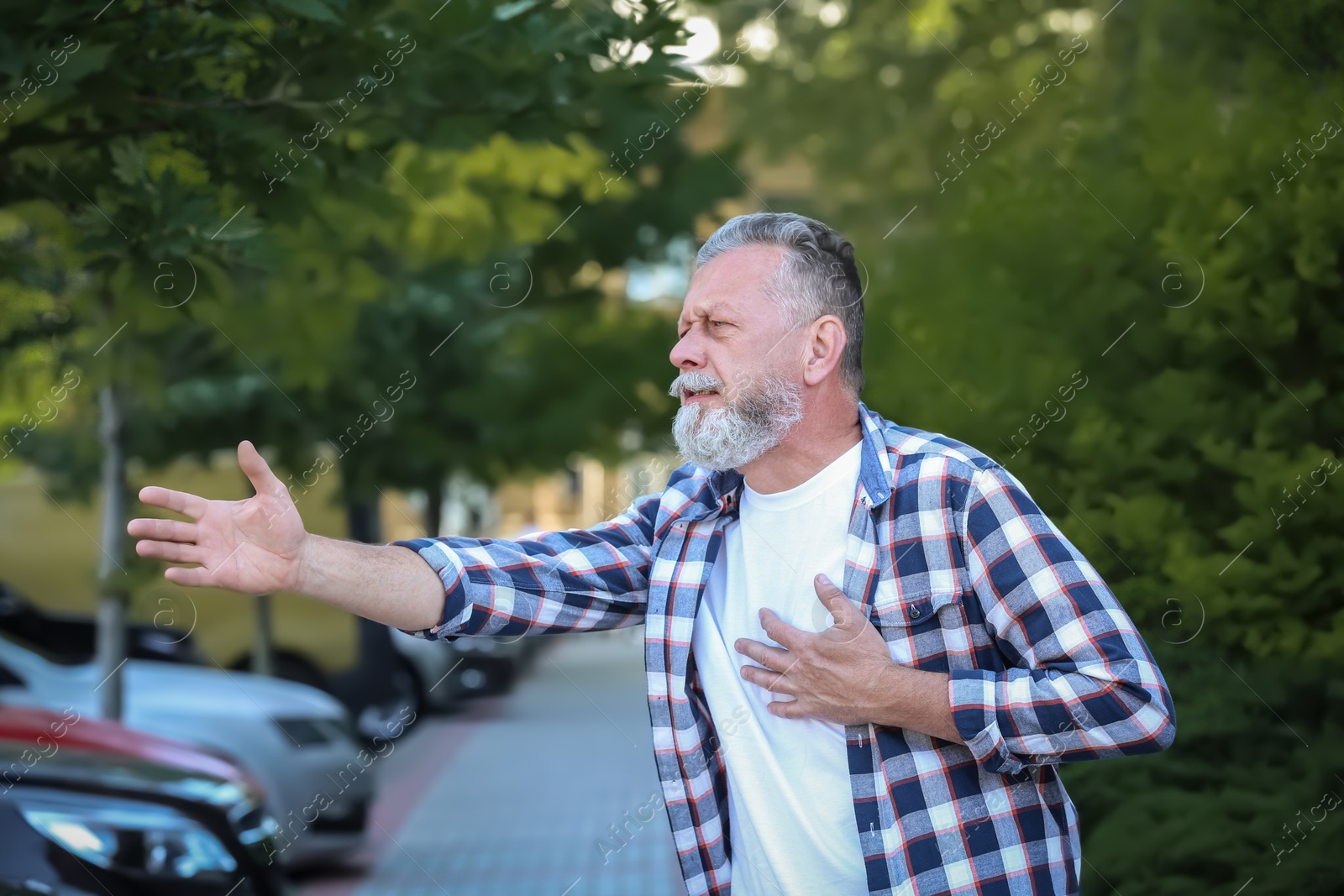 Photo of Mature man having heart attack, outdoors