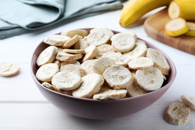 Photo of Freeze dried and fresh bananas on white wooden table, closeup