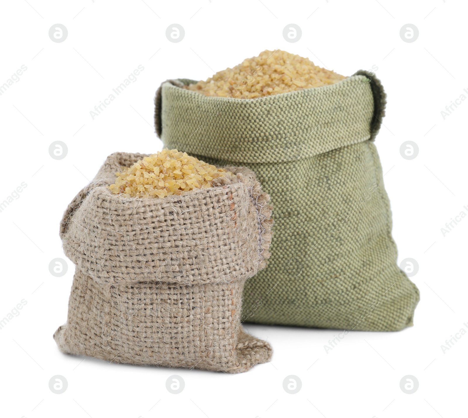 Photo of Burlap bags with uncooked bulgur isolated on white