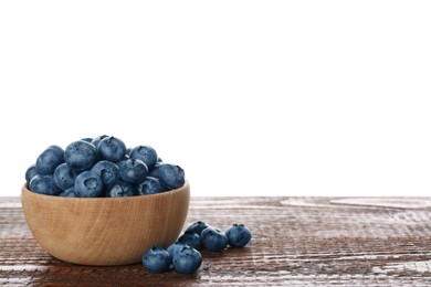 Bowl with tasty fresh blueberries on wooden table against white background