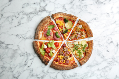 Photo of Slices of different delicious pizzas on white marble table, flat lay