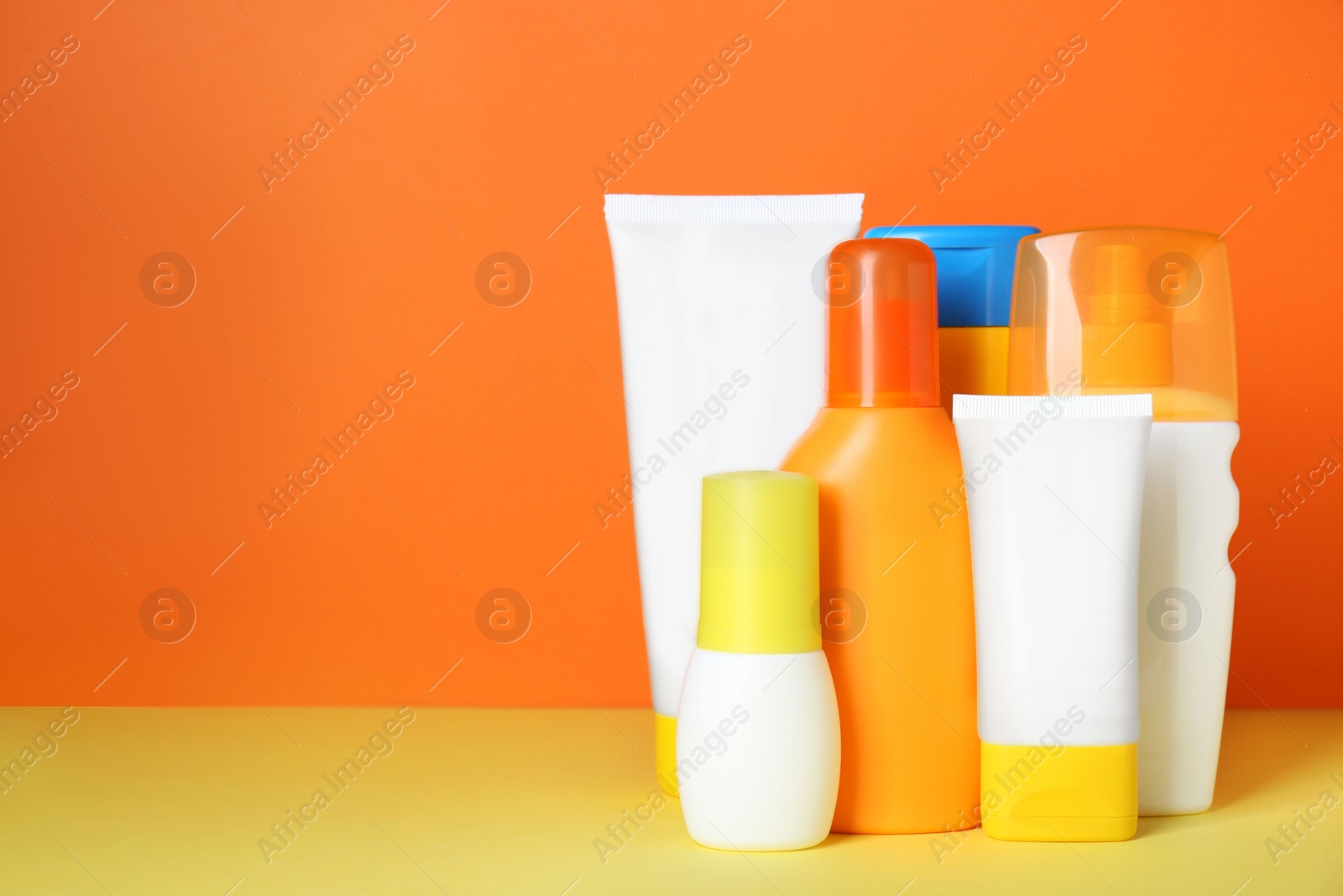 Photo of Different suntan products on color background. Space for text