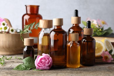 Photo of Aromatherapy. Different essential oils and flowers on wooden table