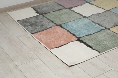 Photo of Soft carpet with pattern on white laminated floor indoors