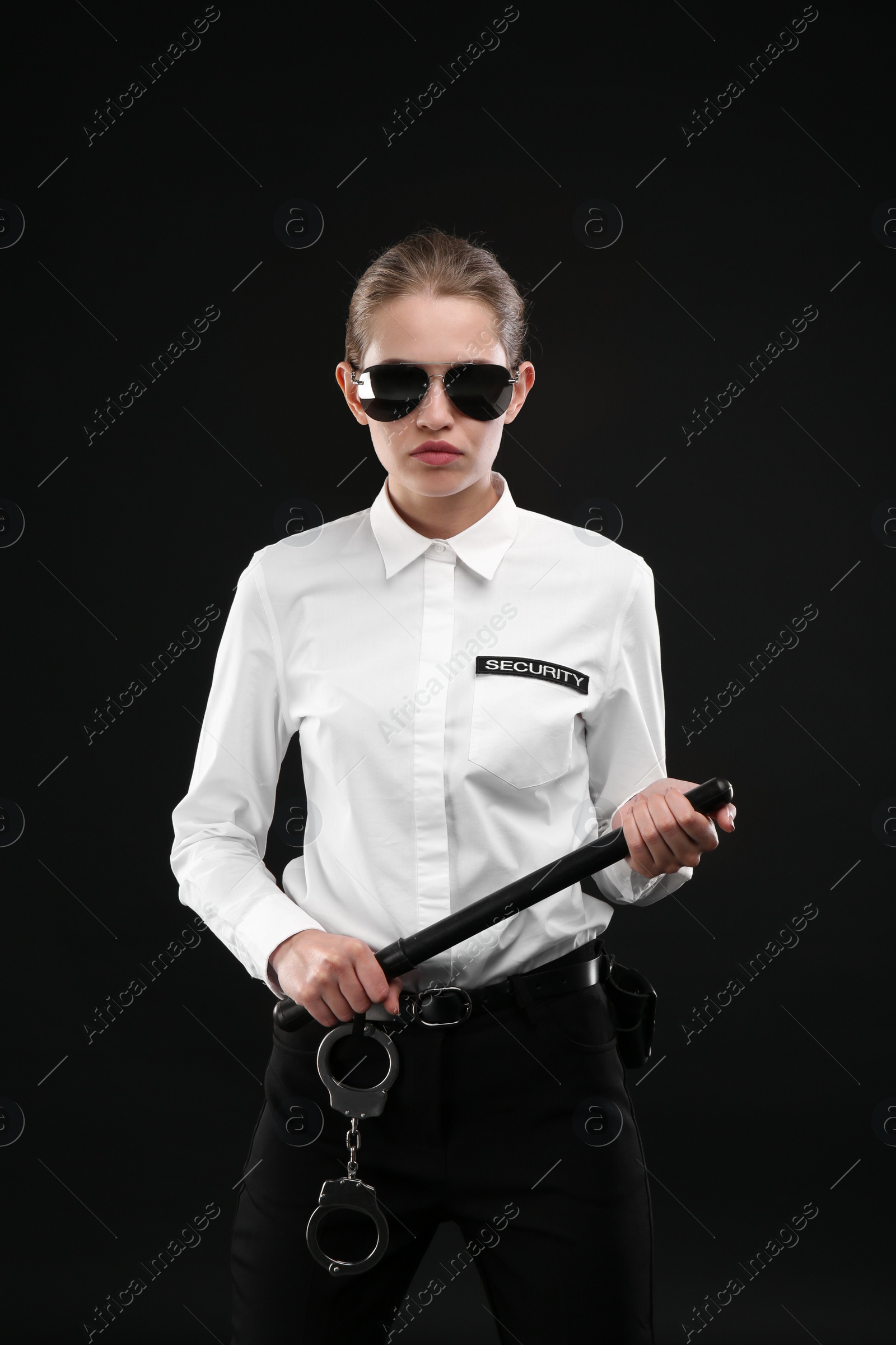 Photo of Female security guard with police baton on dark background