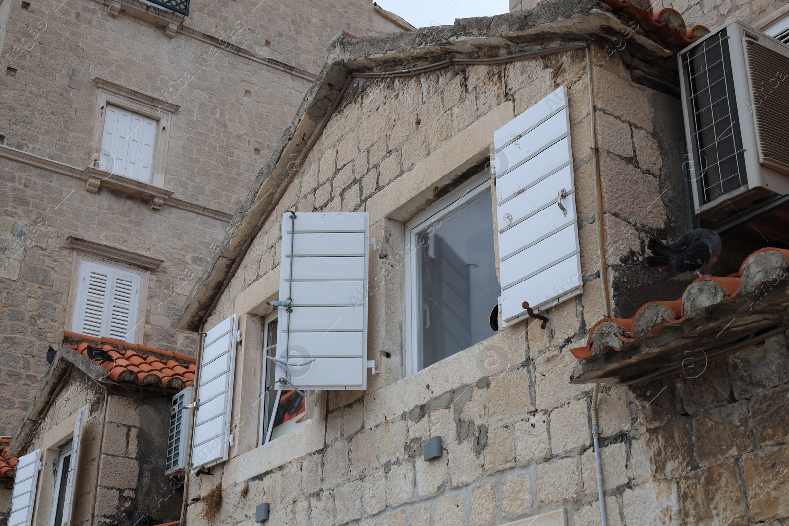 Photo of Beautiful old city buildings with windows, low angle view