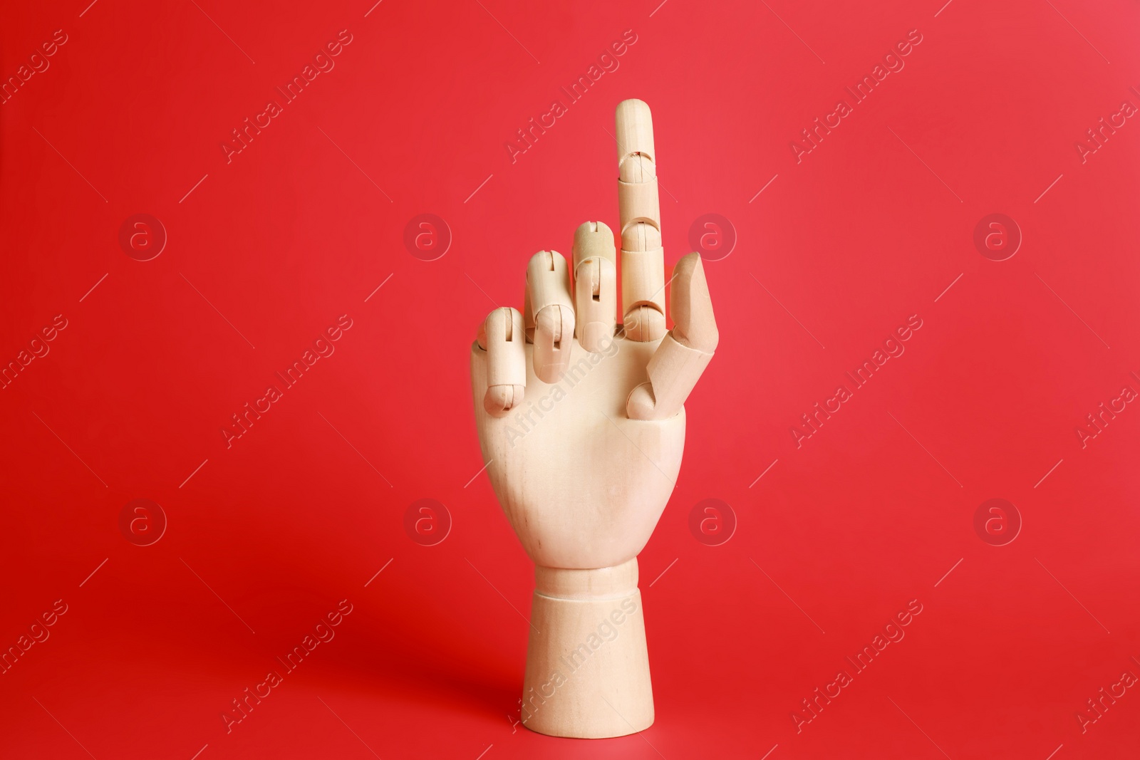 Photo of Wooden hand model on red background. Mannequin part