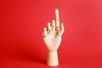 Wooden hand model on red background. Mannequin part