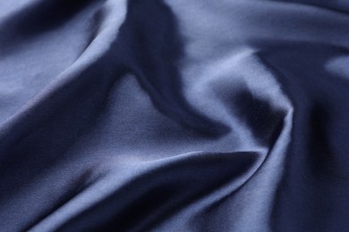 Crumpled dark blue silk fabric as background, closeup