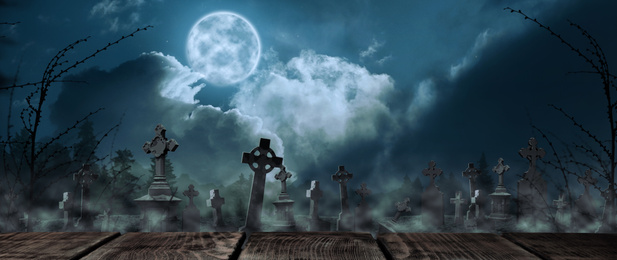 Image of Wooden surface and misty graveyard with old creepy headstones under full moon. Halloween banner design