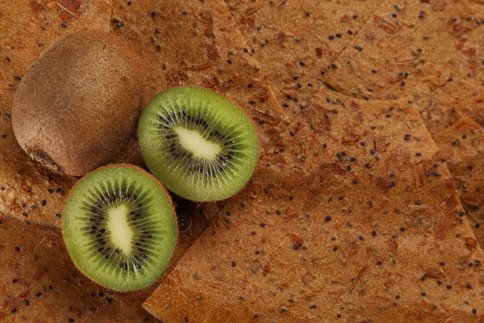 Photo of Kiwis on delicious fruit leather, flat lay. Space for text