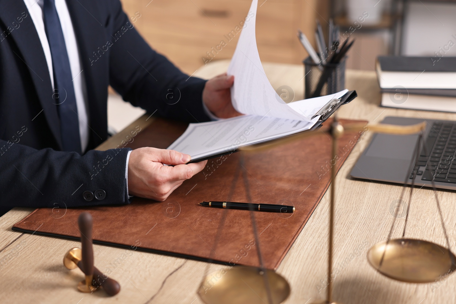Photo of Notary working at wooden table in office, closeup