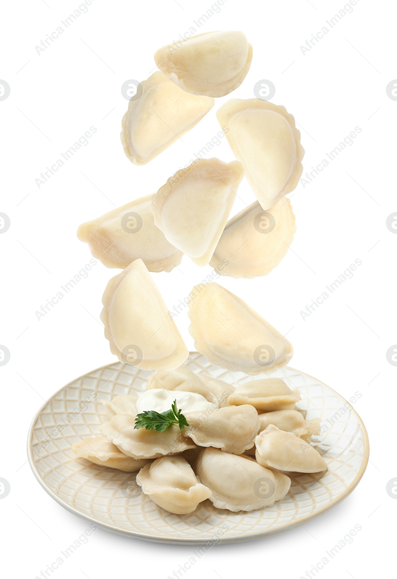 Image of Many tasty dumplings falling on white background