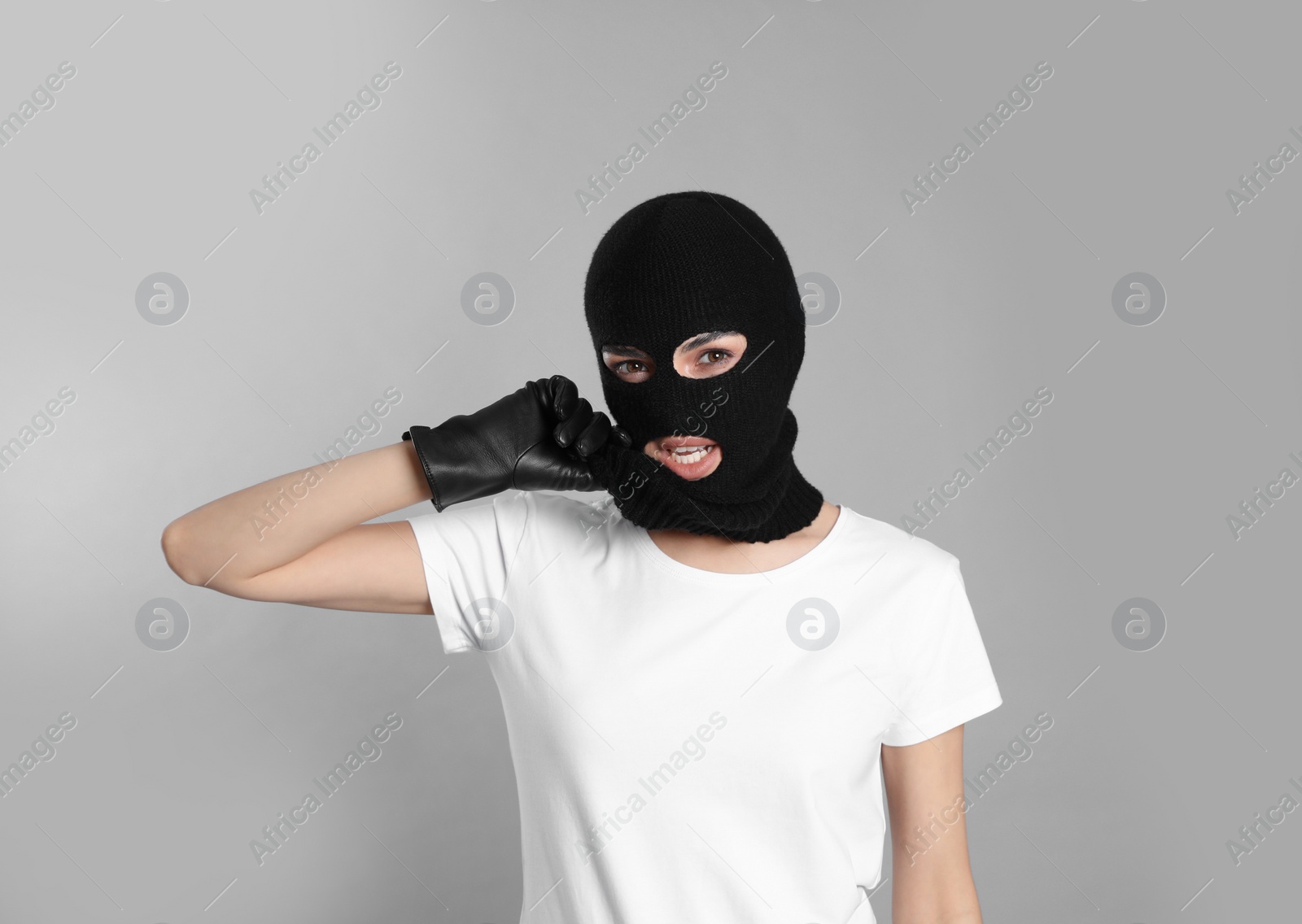 Photo of Woman wearing knitted balaclava on grey background