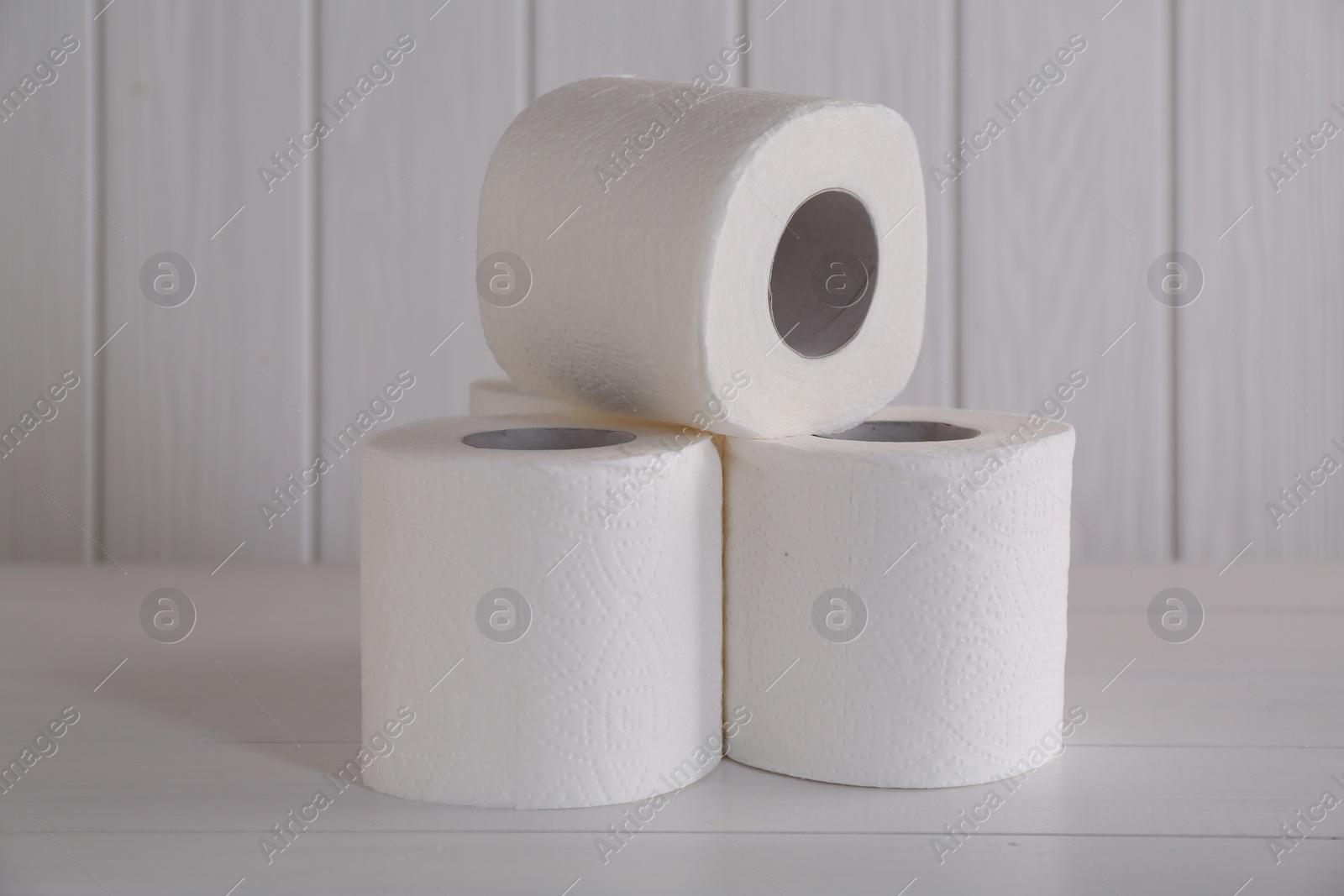 Photo of Many soft toilet paper rolls on white wooden table