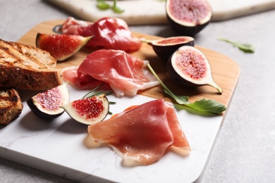 Delicious ripe figs, prosciutto and toasted bread served on table