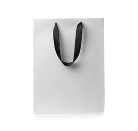 Paper shopping bag with ribbon handles on white background. Mockup for design