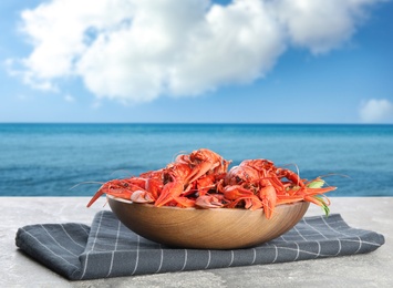 Image of Cooked crayfishes served on grey table near sea