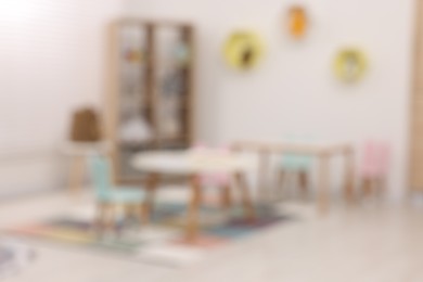 Photo of Stylish kindergarten interior with toys and modern furniture, blurred view