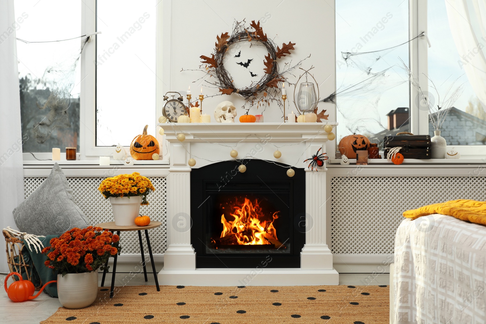 Photo of Modern room with fireplace decorated for Halloween. Festive interior