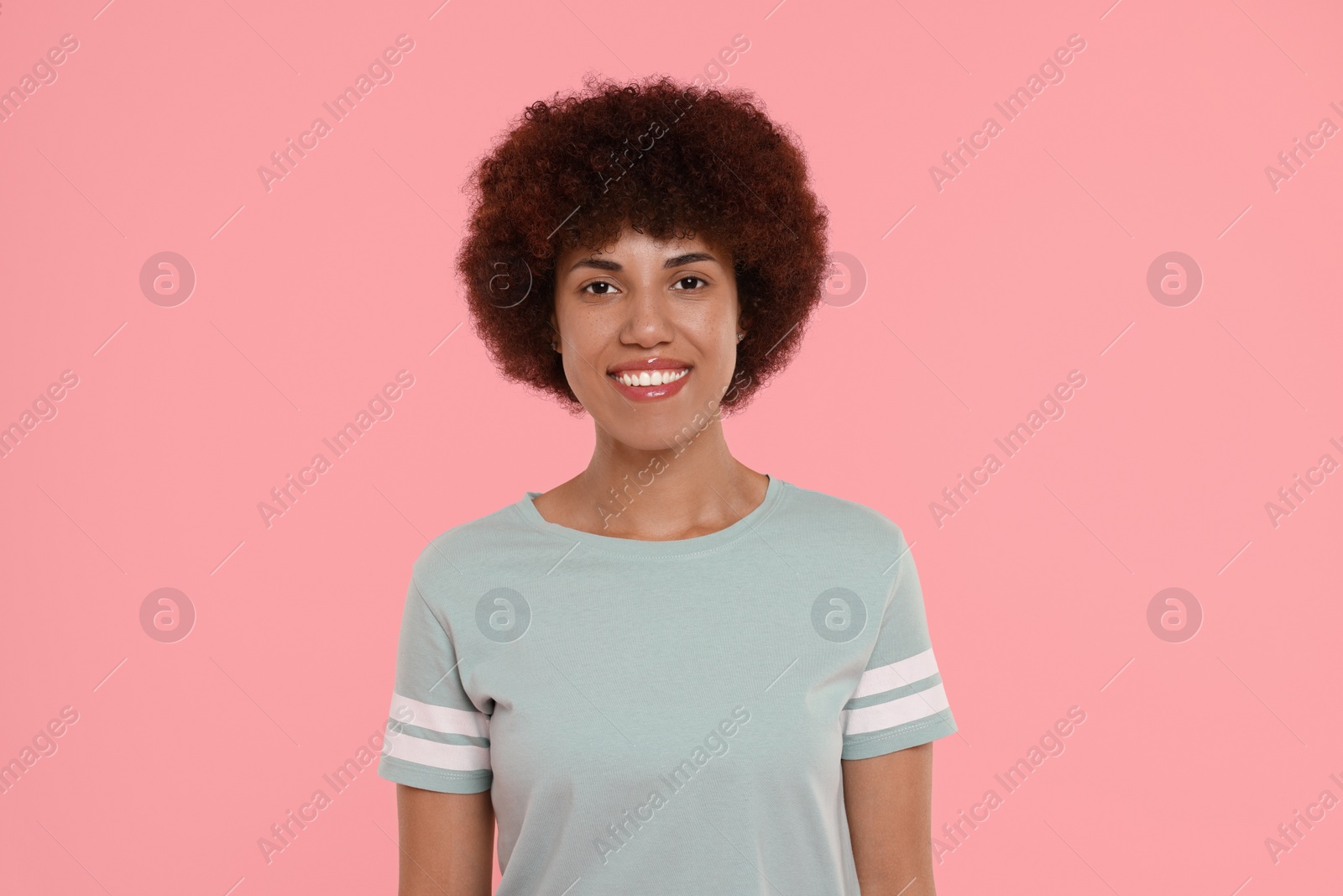 Photo of Portrait of happy young woman on pink background