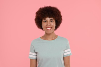 Portrait of happy young woman on pink background