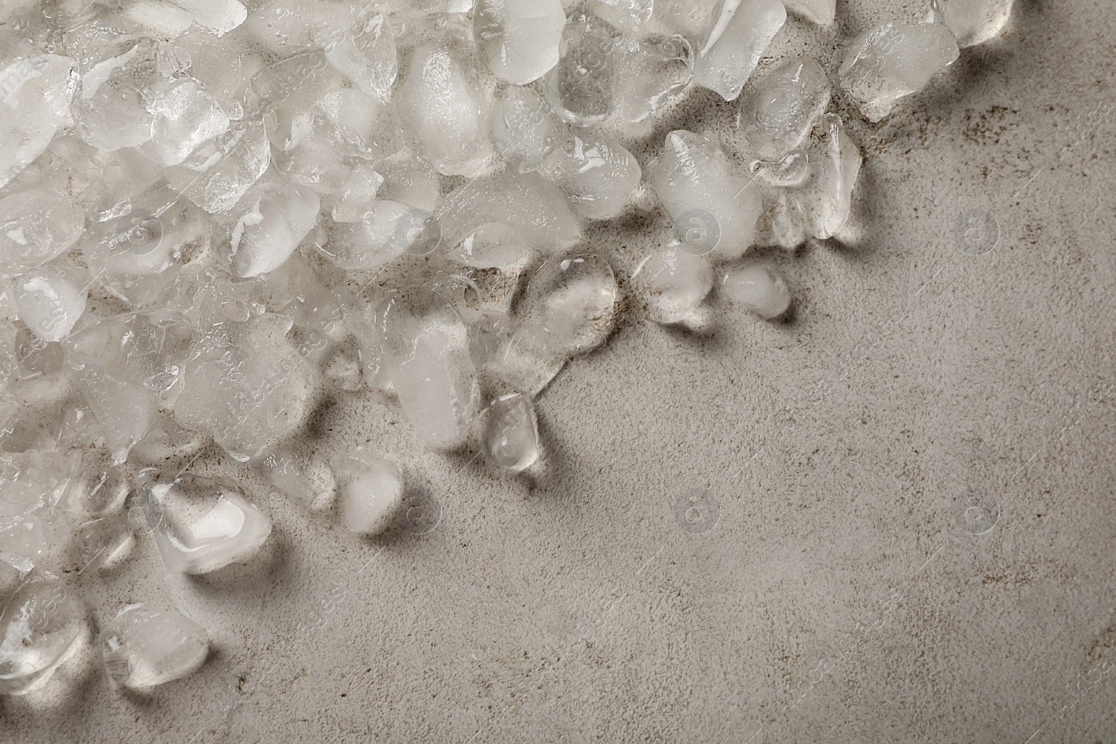 Photo of Pile of crushed ice on light grey table, closeup. Space for text