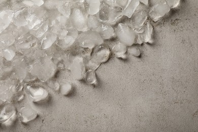 Pile of crushed ice on light grey table, closeup. Space for text