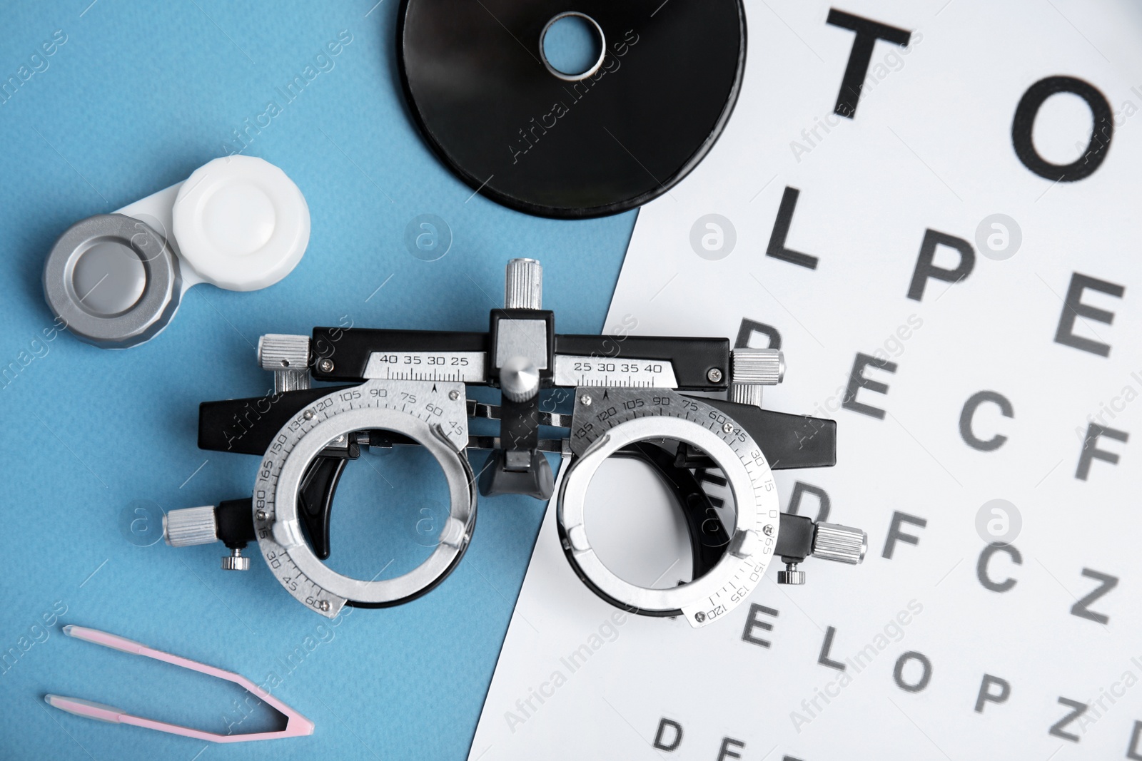 Photo of Different ophthalmologist tools on light blue background, flat lay