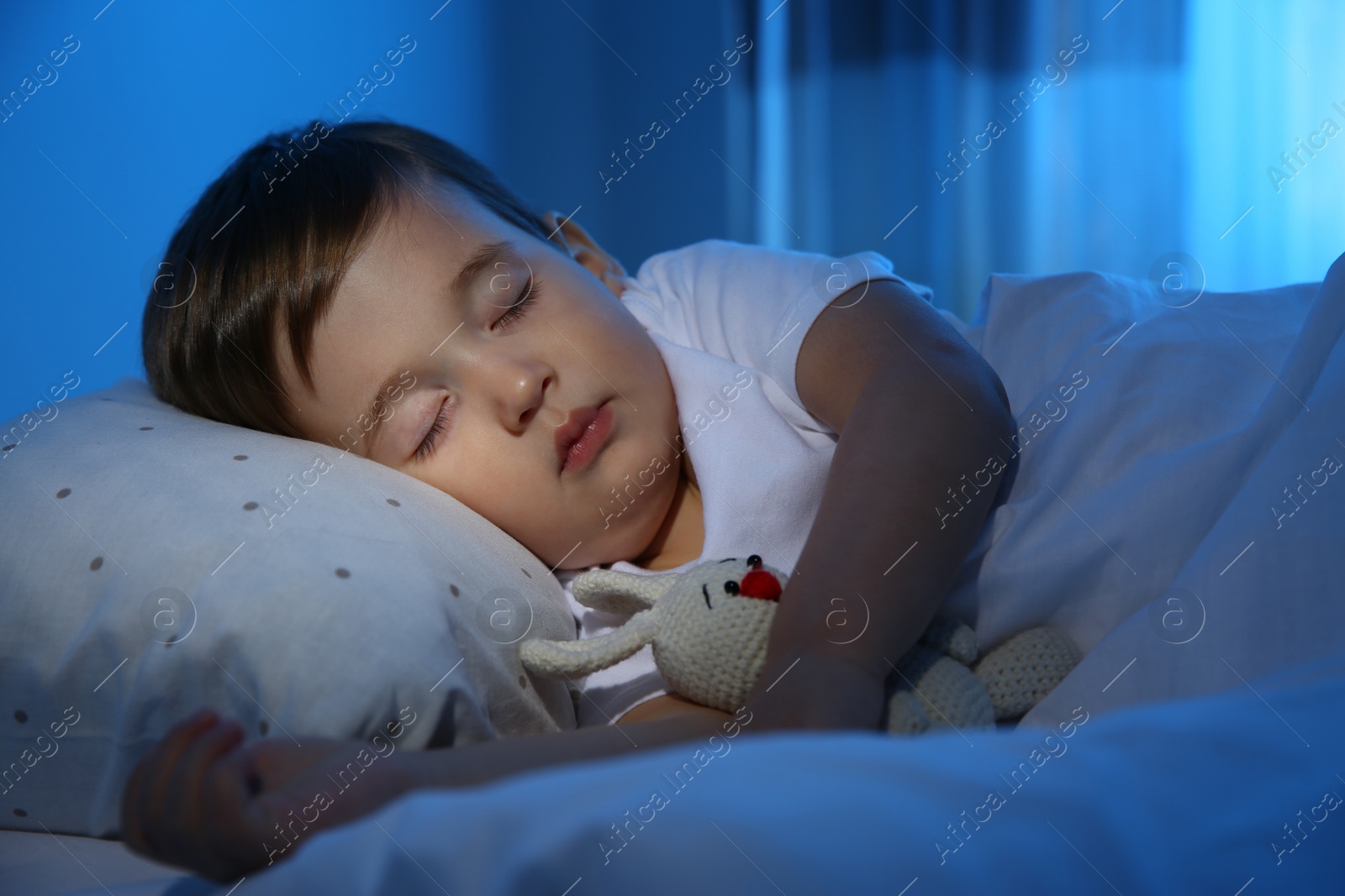 Photo of Cute little baby sleeping with toy at home. Bedtime